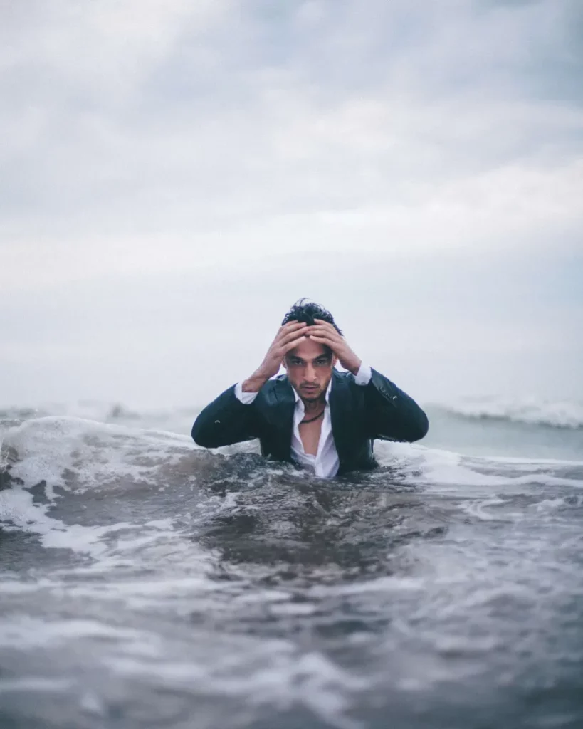 Man with business clothes swimming in ocean